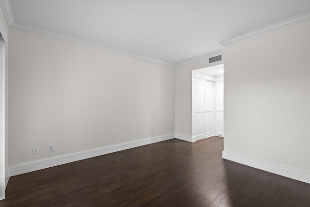 empty room with baseboards, crown molding, visible vents, and dark wood-type flooring