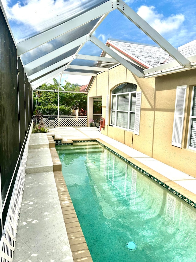 view of swimming pool featuring a patio and a lanai