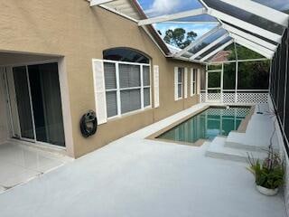 view of swimming pool featuring a lanai and a patio