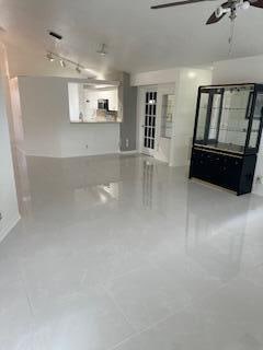 unfurnished living room with tile patterned flooring and ceiling fan