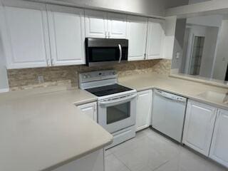 kitchen with white cabinets, light tile patterned floors, white appliances, and backsplash