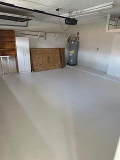 garage featuring electric water heater and a garage door opener