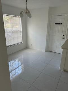 unfurnished dining area featuring light tile patterned floors