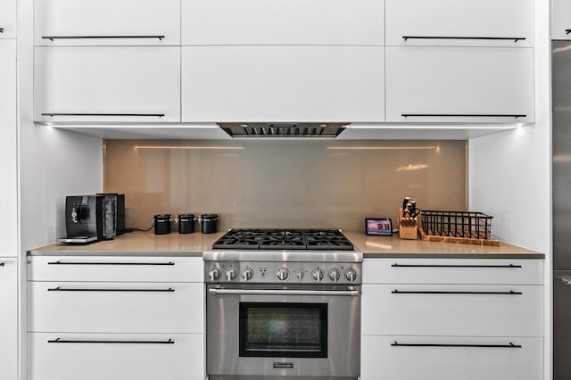 kitchen featuring white cabinets, light countertops, and high end range