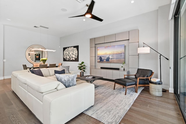 living area featuring ceiling fan, recessed lighting, wood finished floors, and baseboards