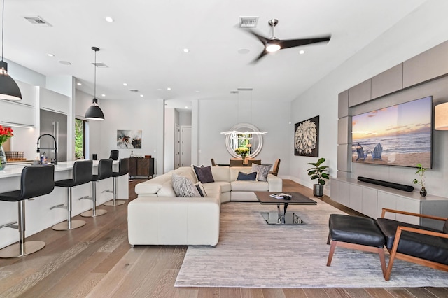 living room with ceiling fan and light hardwood / wood-style floors