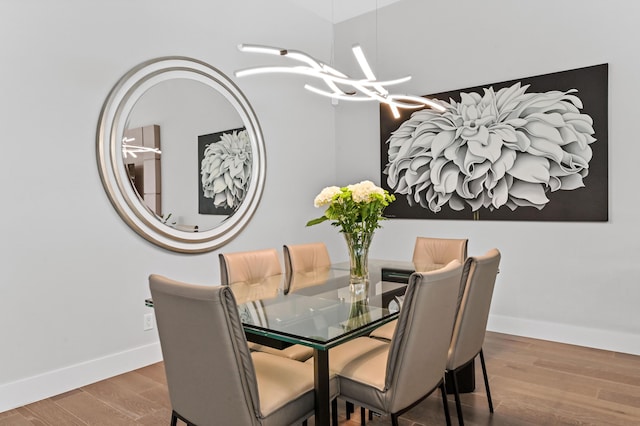 dining area with a notable chandelier, baseboards, and wood finished floors