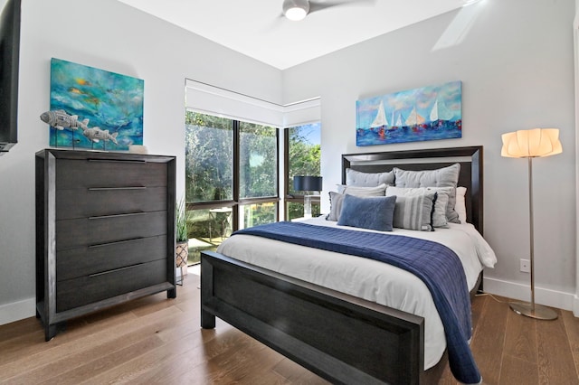 bedroom featuring a ceiling fan, baseboards, and wood finished floors