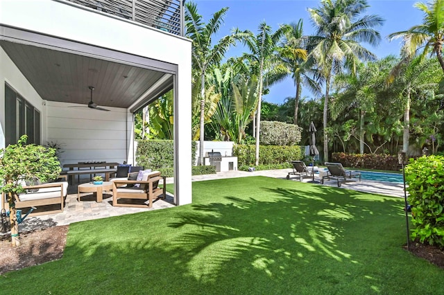 view of yard featuring a patio area, ceiling fan, an outdoor kitchen, and an outdoor hangout area