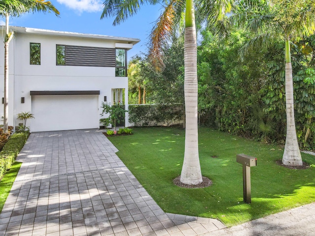 view of front of home featuring a front yard and a garage