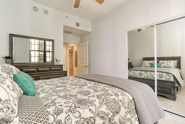 bedroom featuring ceiling fan, light colored carpet, high vaulted ceiling, and a closet