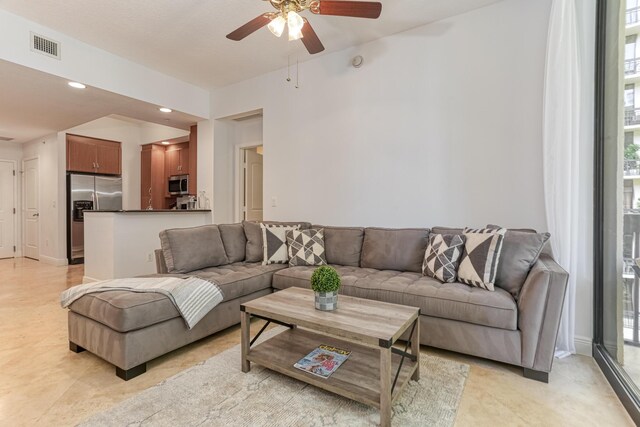 living room with ceiling fan, light tile patterned flooring, and plenty of natural light