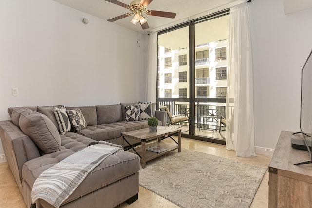 living room featuring ceiling fan, a wealth of natural light, and a wall of windows