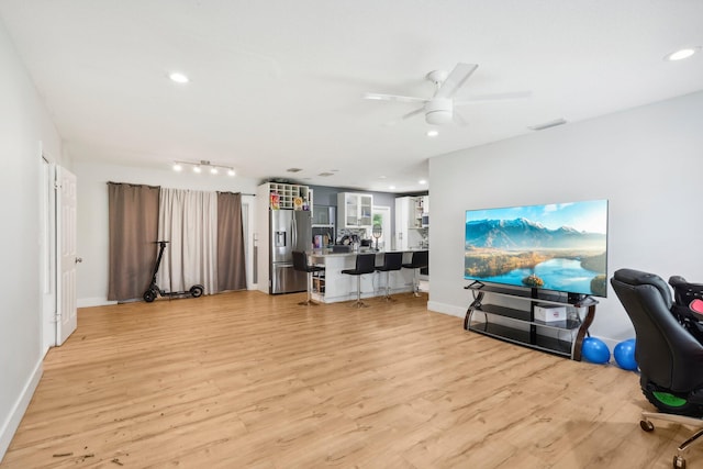 living room featuring light hardwood / wood-style flooring and ceiling fan