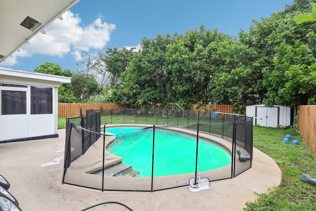 view of pool with a patio area, a lawn, and a storage shed