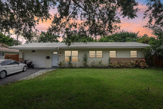 single story home with a lawn and a garage