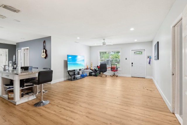 living room featuring ceiling fan and light hardwood / wood-style floors