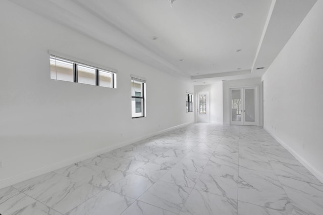 empty room with a raised ceiling and french doors