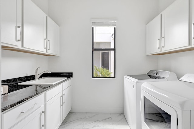 washroom with cabinets, independent washer and dryer, and sink