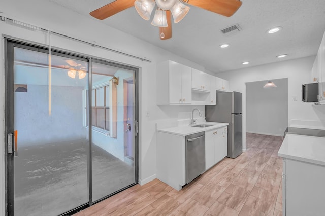 kitchen featuring ceiling fan, appliances with stainless steel finishes, and white cabinets