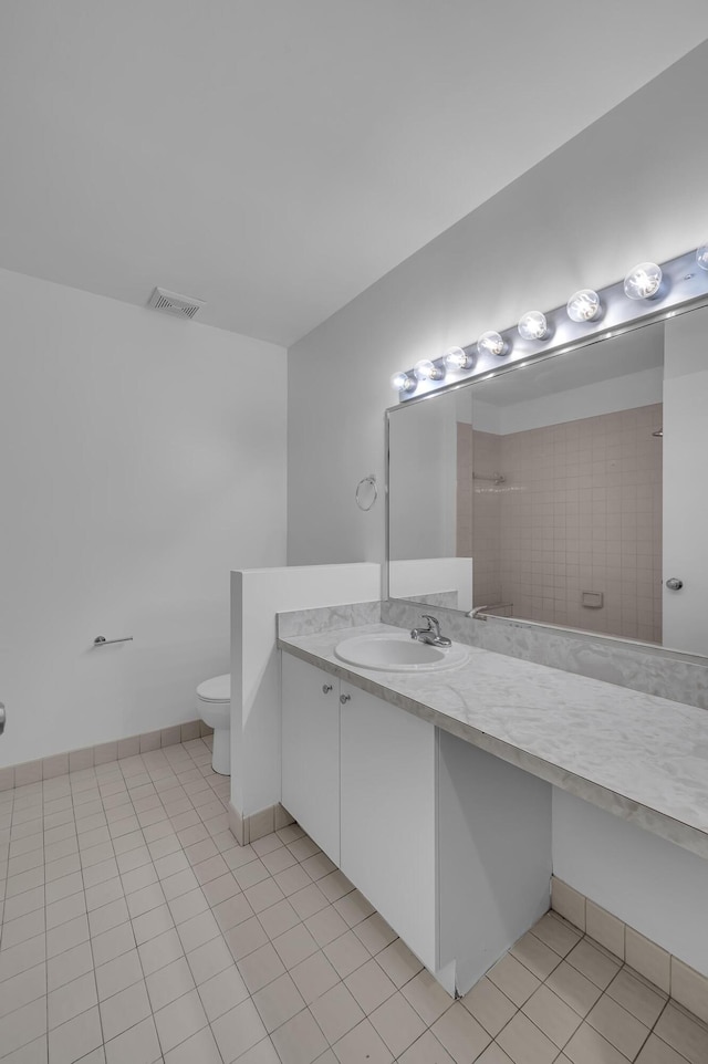 bathroom featuring vanity, tile patterned flooring, and toilet