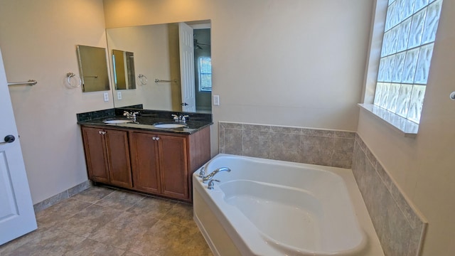 bathroom with vanity, a tub to relax in, and a healthy amount of sunlight