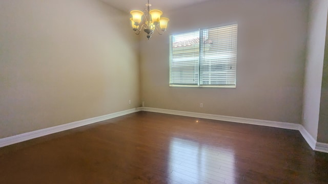 unfurnished room with dark hardwood / wood-style floors and a chandelier