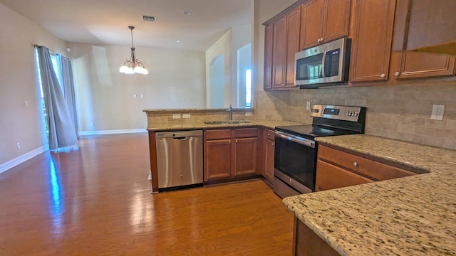 kitchen with a healthy amount of sunlight, hardwood / wood-style flooring, stainless steel appliances, and sink