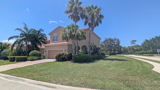 mediterranean / spanish-style house featuring a front yard and a garage