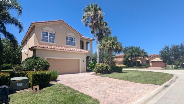 mediterranean / spanish-style house with a garage and a front lawn