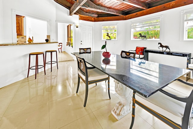 tiled dining area featuring beam ceiling and wooden ceiling