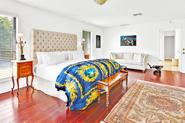 bedroom featuring dark wood-type flooring and a textured ceiling