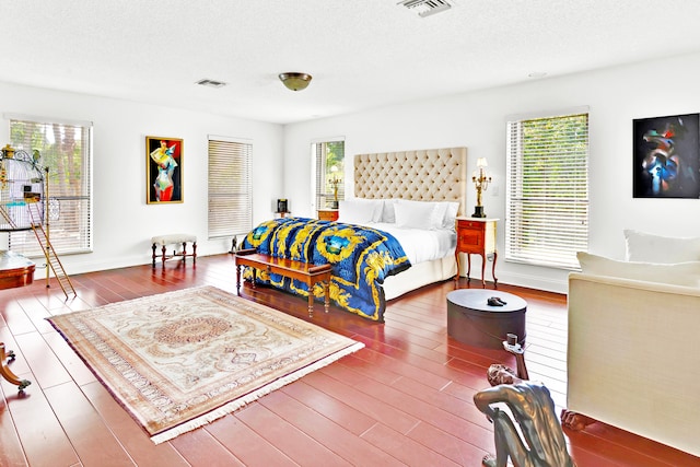 bedroom featuring hardwood / wood-style flooring and a textured ceiling