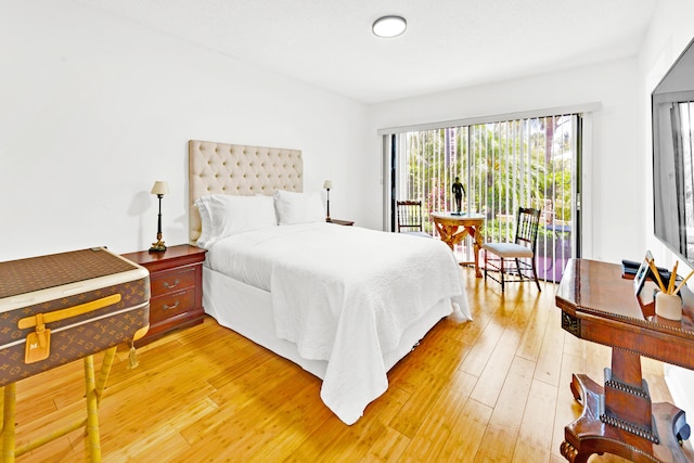 bedroom with wood-type flooring and access to exterior