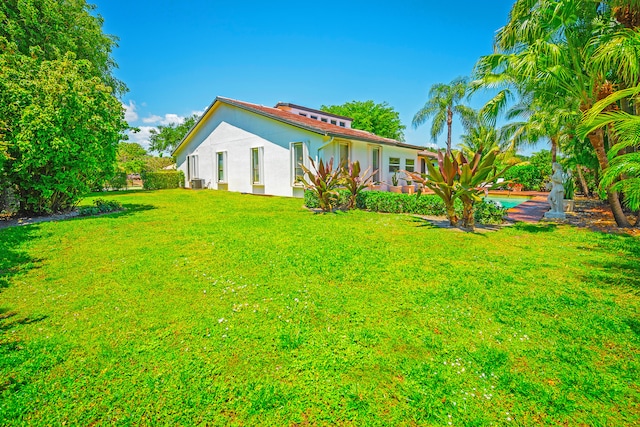 exterior space with a yard and central air condition unit