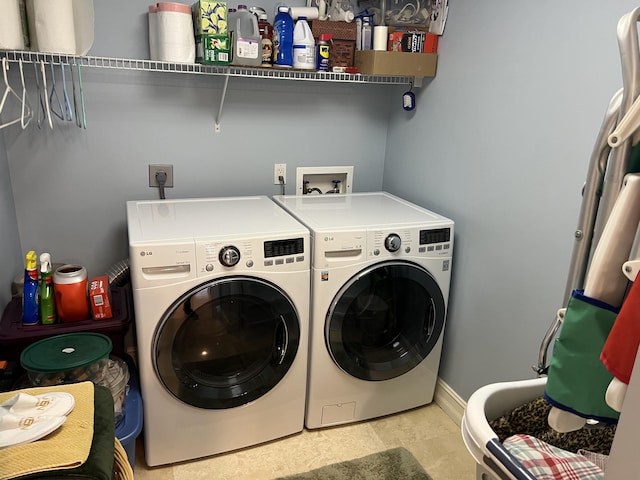 laundry area featuring light tile patterned floors and washer and clothes dryer