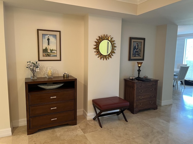 hall with light tile patterned flooring and ornamental molding