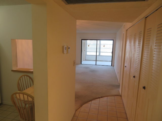 hallway featuring light colored carpet