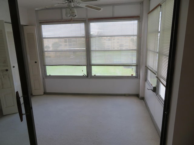 unfurnished sunroom with ceiling fan and a healthy amount of sunlight