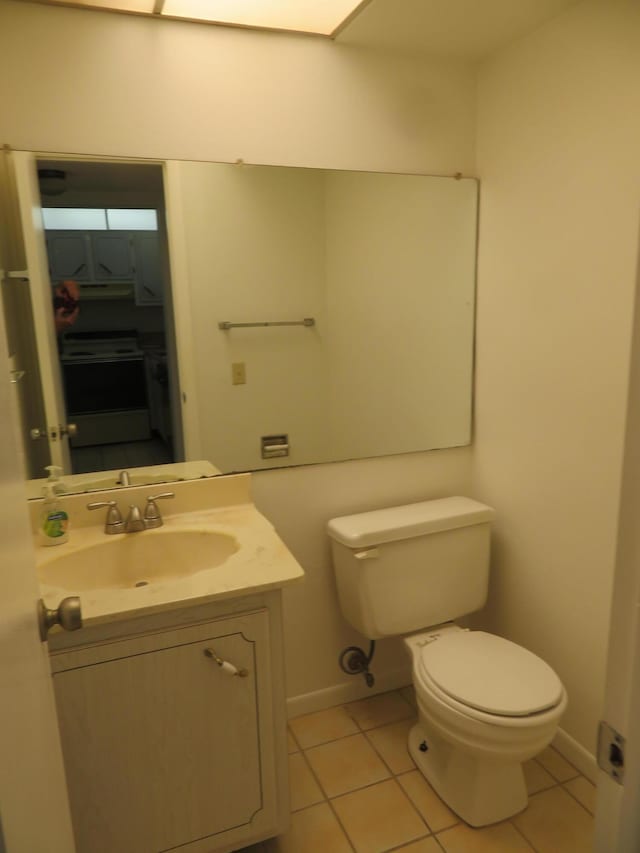 bathroom with toilet, tile patterned floors, and vanity