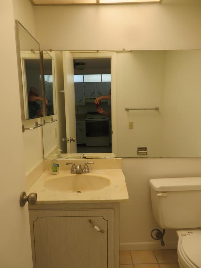 bathroom featuring toilet, vanity, and tile patterned flooring