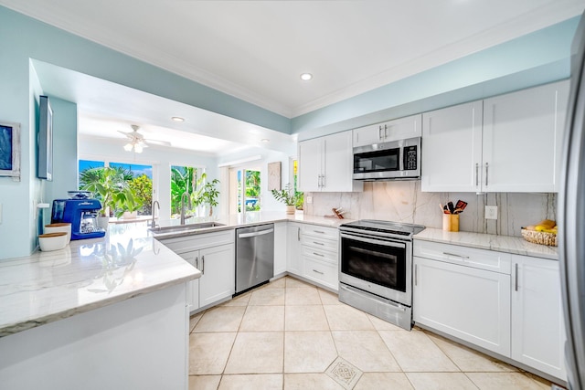 kitchen with appliances with stainless steel finishes, tasteful backsplash, white cabinetry, and ceiling fan