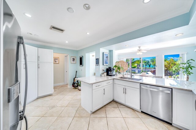 kitchen with stainless steel appliances, ceiling fan, sink, white cabinetry, and kitchen peninsula