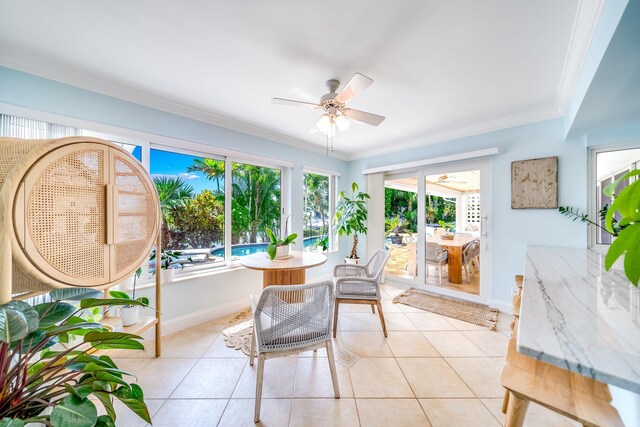 tiled dining space featuring ceiling fan and ornamental molding