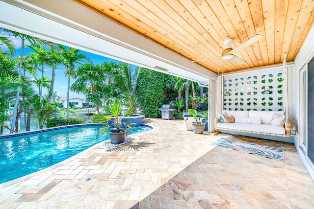 view of pool featuring ceiling fan, a grill, and a patio area