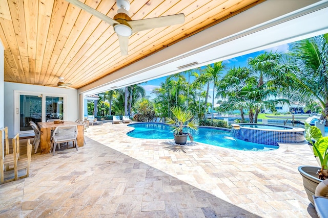 view of swimming pool with pool water feature, an in ground hot tub, a patio, and ceiling fan