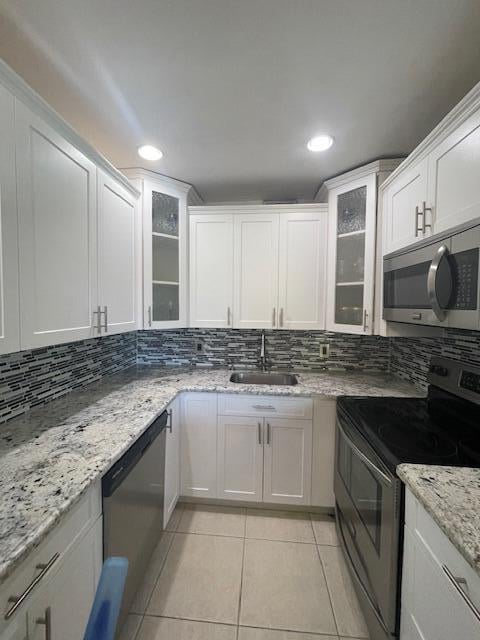 kitchen with stainless steel appliances, sink, and white cabinetry