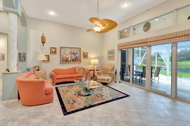 living room featuring a ceiling fan, recessed lighting, light tile patterned flooring, and a towering ceiling