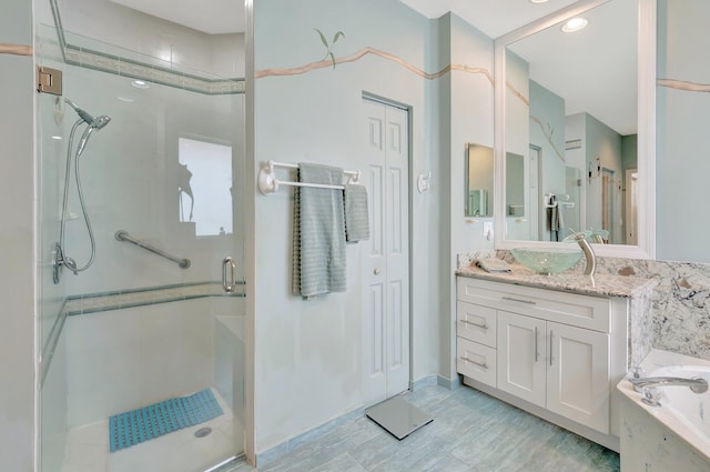 full bathroom with a bath, a closet, a shower stall, and vanity