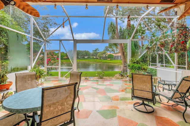 sunroom featuring a water view